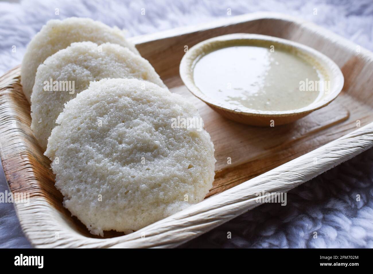 Deliziosa colazione tipica indiana del sud con chutney bianco servita in piatto. Foto Stock