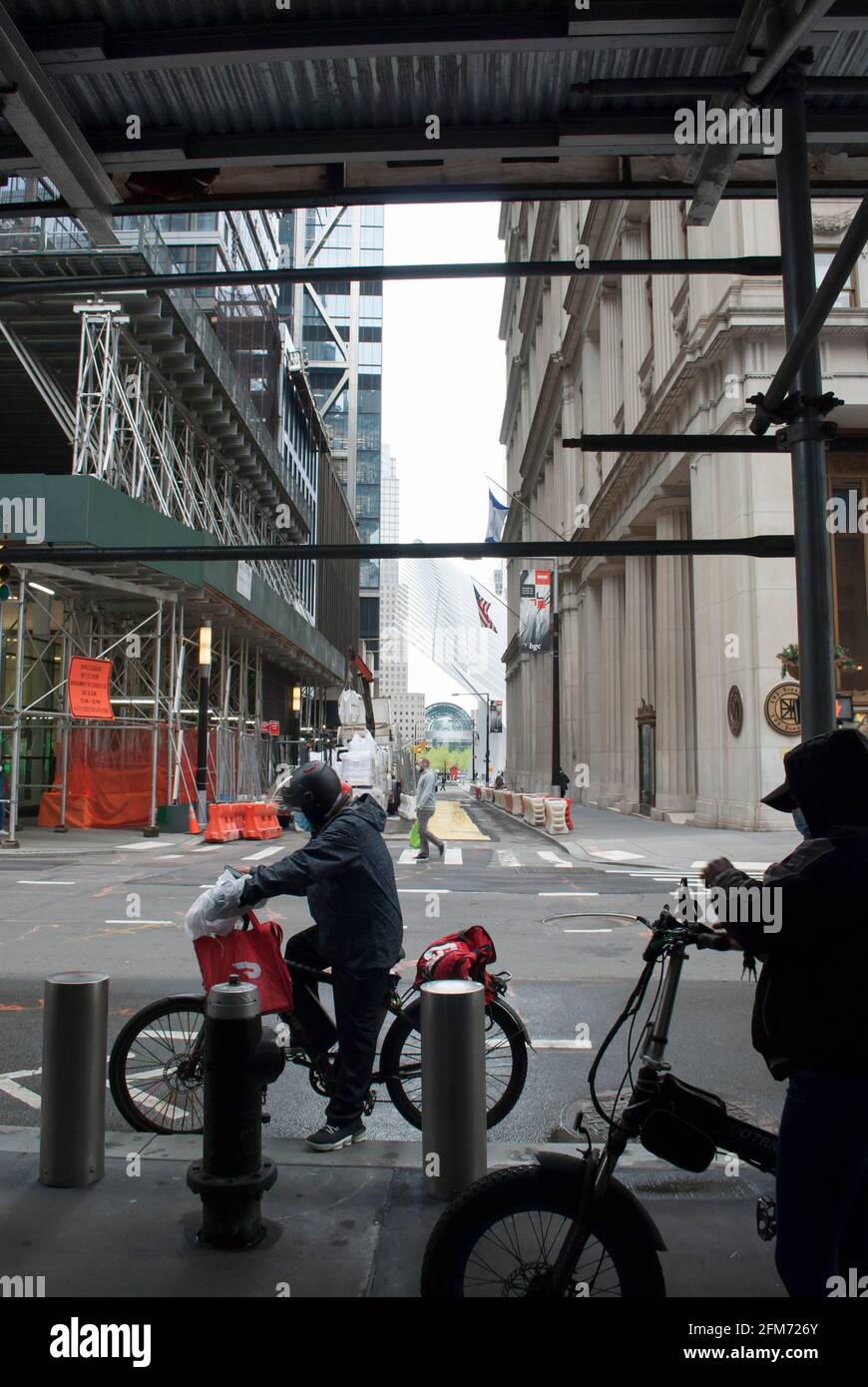 L'uomo sta lavorando per l'azienda di consegna del cibo. Biciclette di New York. L'uomo sta guidando una bici con i sacchetti rossi per la consegna del cibo a Manhattan. Foto Stock