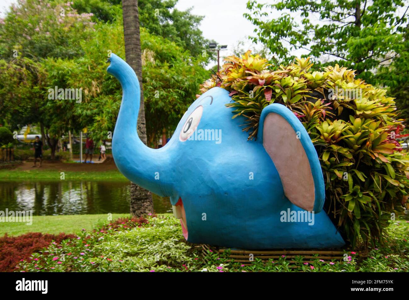 Divertente scultura di elefante blu con piante che crescono sulla testa nel parco Foto Stock