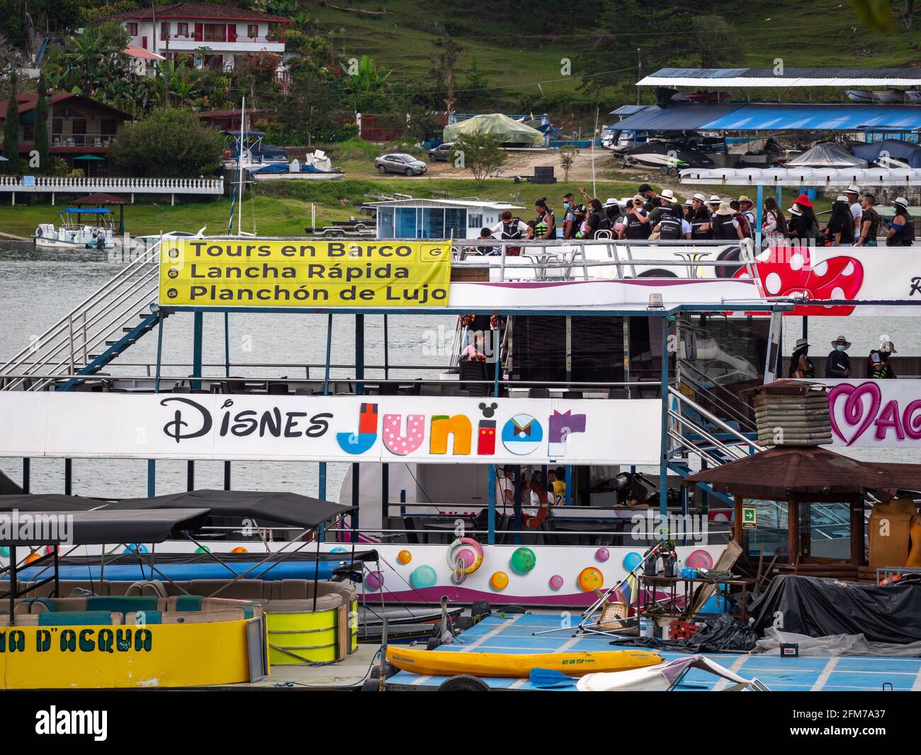 Guatape, Antioquia, Colombia - 3 aprile 2021: Barche, motoscafo e motoscafo di lusso Offerte tour con un sacco di persone in varie piccole imbarcazioni da diporto a t Foto Stock