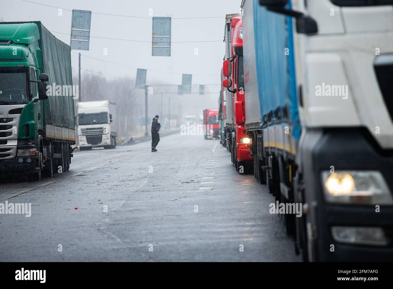 Un lungo ingorgo di molti camion al confine , una lunga attesa per i controlli doganali tra gli stati a causa dell'epidemia di coronavirus, aumento sanitario in Foto Stock