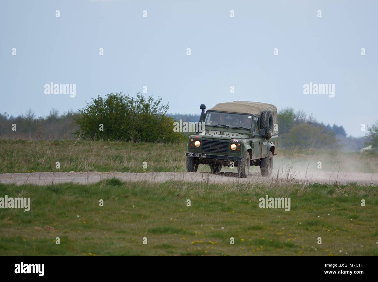 Un British Army Land Rover Defender si fa strada lungo una polverosa pista di pietra, in manovre Foto Stock