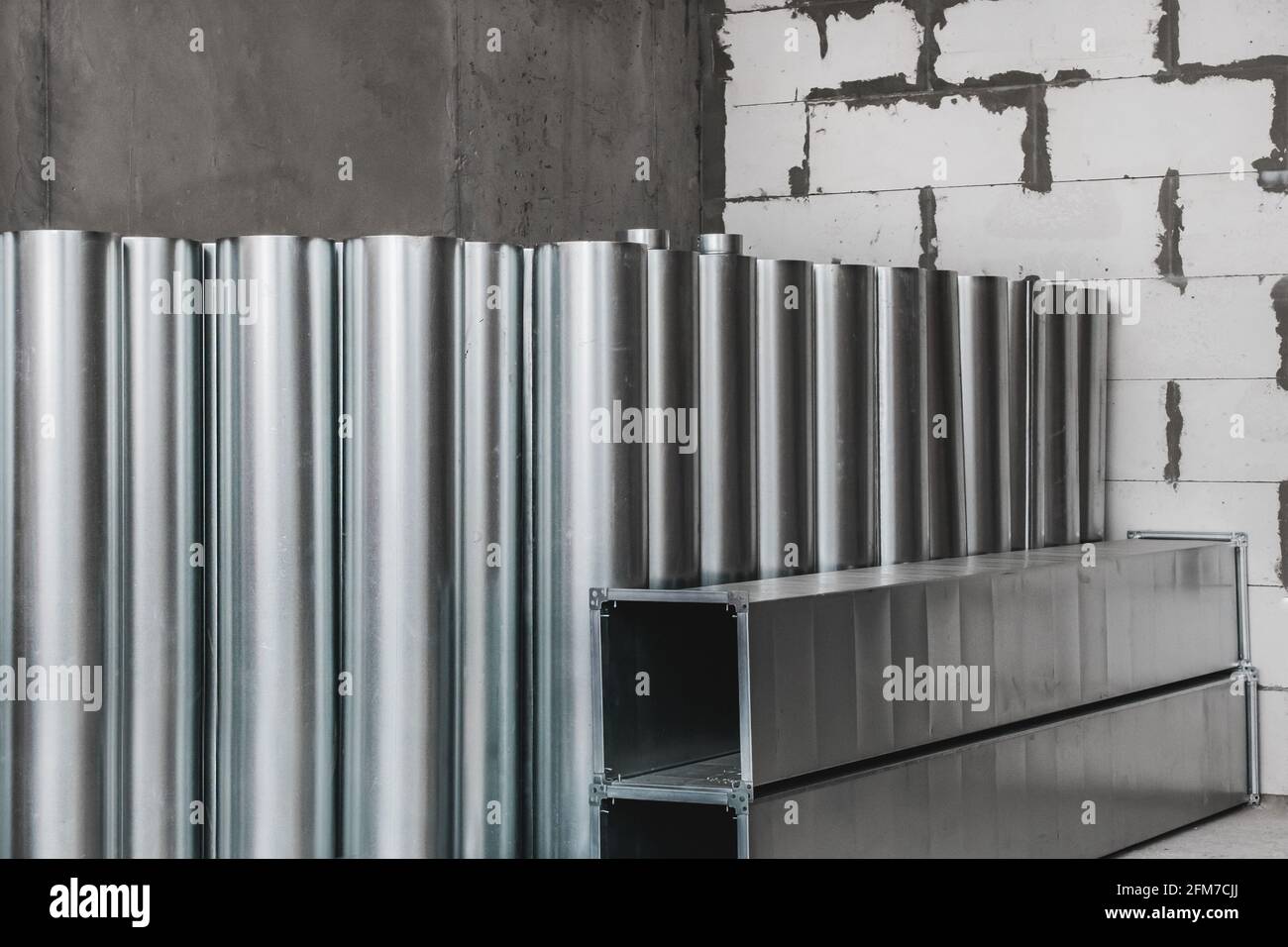 Pila di tubi di metallo rotondi ad un luogo di costruzione. Stoccaggio tubi in acciaio materiali industriali in magazzino. Foto Stock