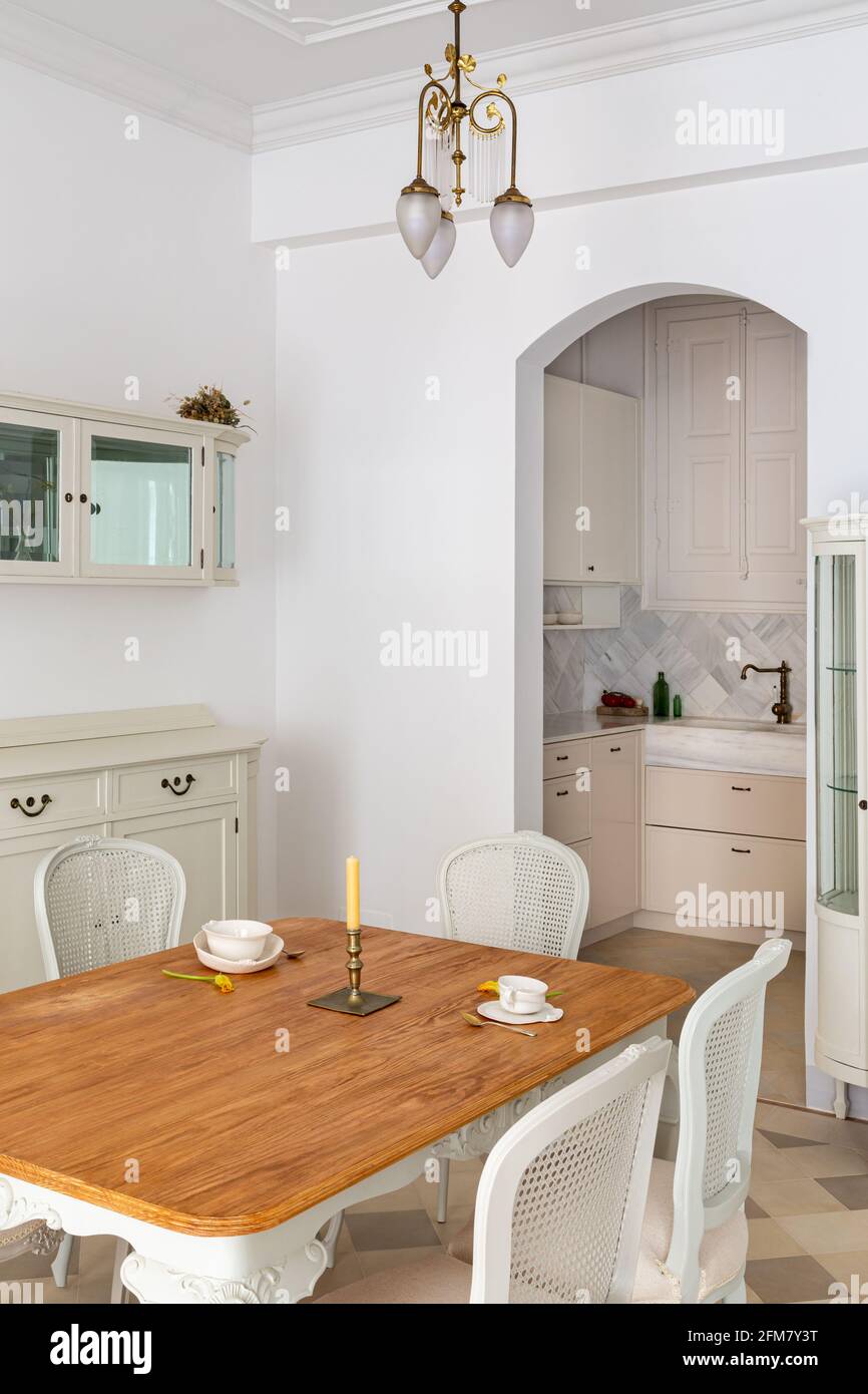 Tavolo da pranzo in legno servito per due persone in soggiorno classico  decorato in stile retrò con vista sulla cucina Foto stock - Alamy