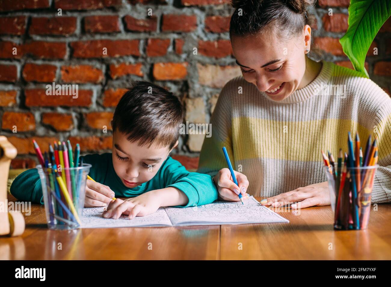 Bambino e adulto stanno disegnando un libro da colorare. Foto Stock