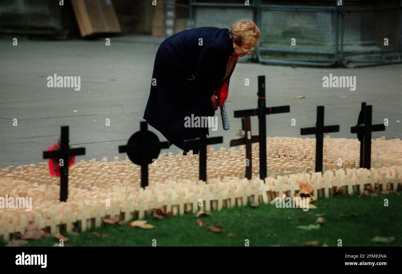 Nov 2000 una donna in cerca di nomi sulle croci all'esterno I papaveri del giorno della memoria dell'Abbazia di Westminster sono raffigurati all'Abbazia di Westminster Foto Stock