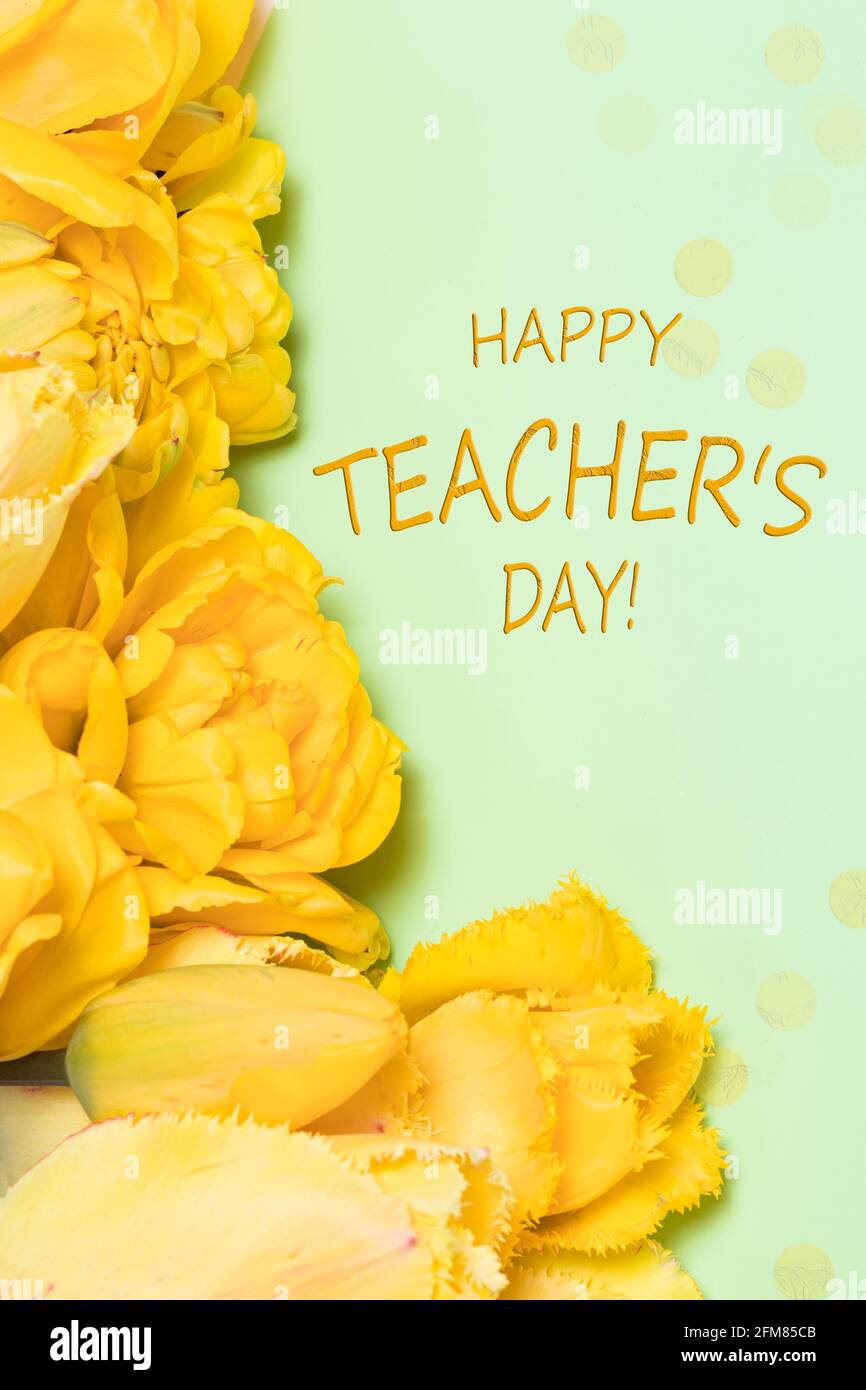 Banner verticale con fiori di tulipano gialli su sfondo verde Con l'iscrizione Happy Teacher's Day Foto Stock