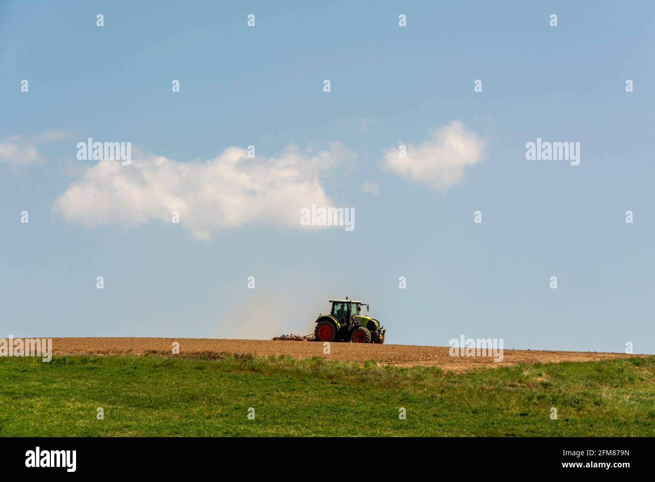 Campo di aratura del trattore , dipartimento Puy de Dome, Auvergne-Rhone-Alpes, Francia Foto Stock