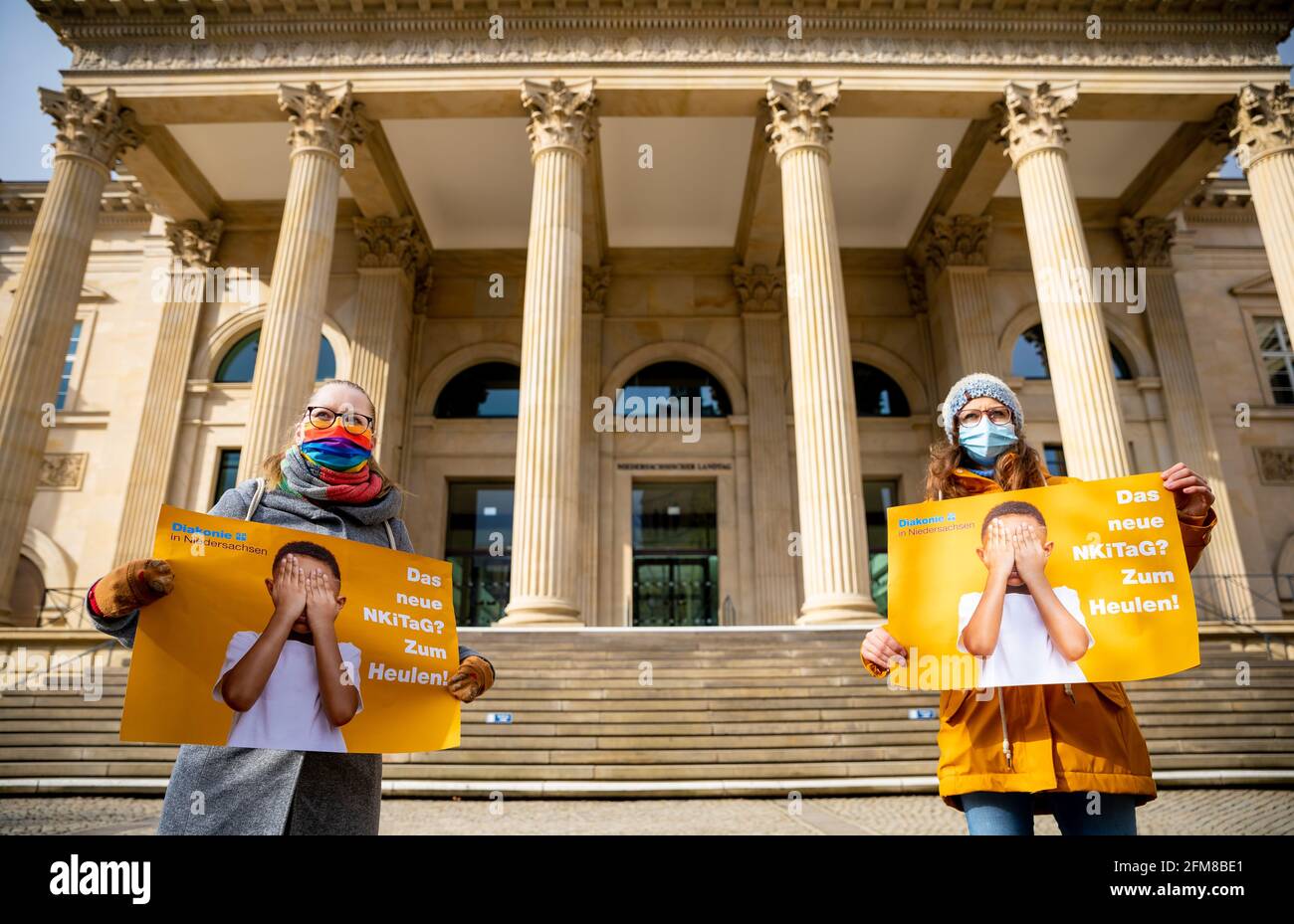 Hannover, Germania. 07 maggio 2021. Durante una dimostrazione davanti al parlamento di Stato, due insegnanti di asilo tengono manifesti con lo slogan 'il nuovo NKiTaG? Basta far piangere! Oggi, il comitato culturale del parlamento statale della bassa Sassonia sta discutendo una nuova legge sull'asilo. Credit: Moritz Frankenberg/dpa/Alamy Live News Foto Stock