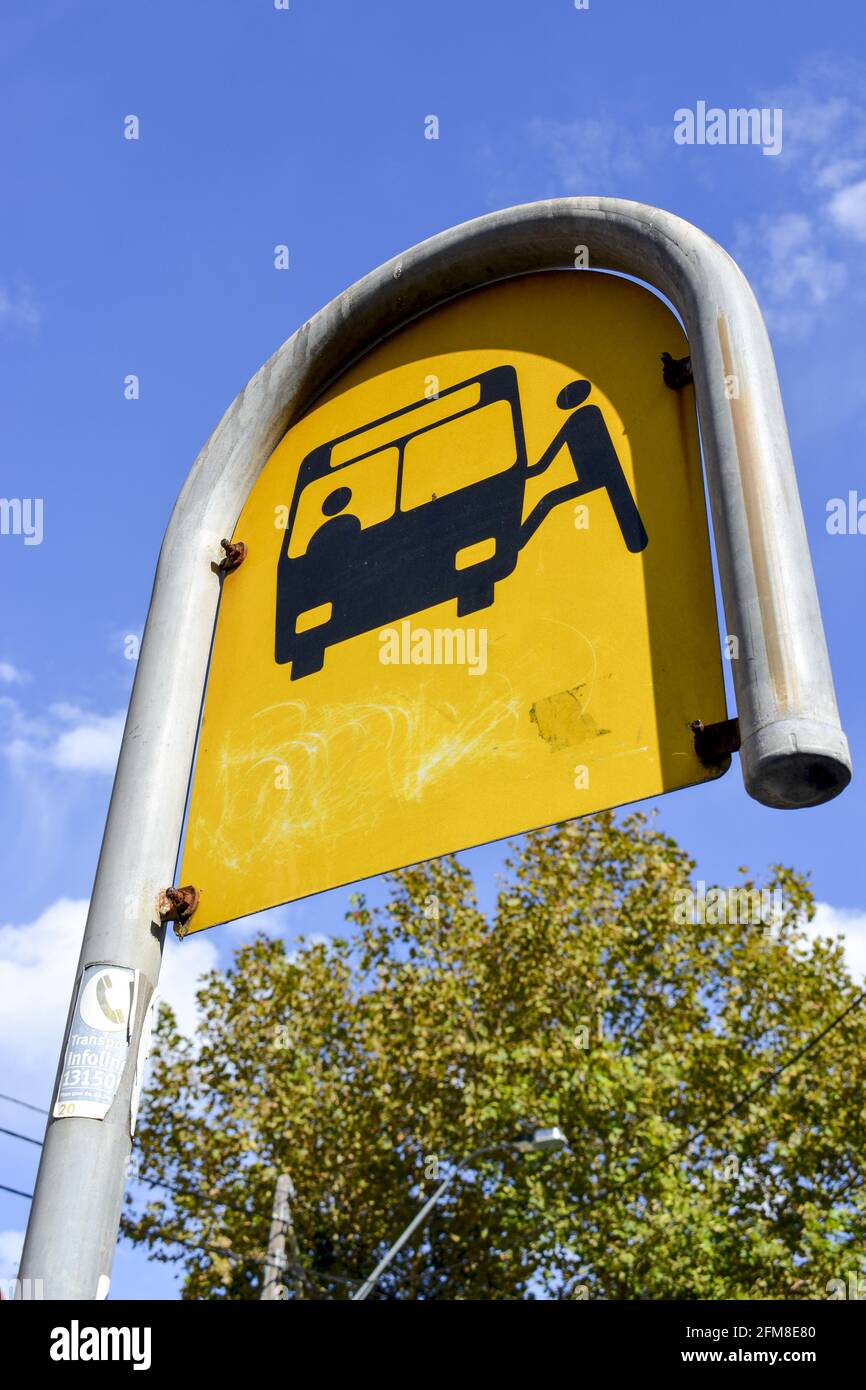 Basso angolo della fermata dell'autobus verniciata di giallo metallizzato cartello sulla strada Foto Stock