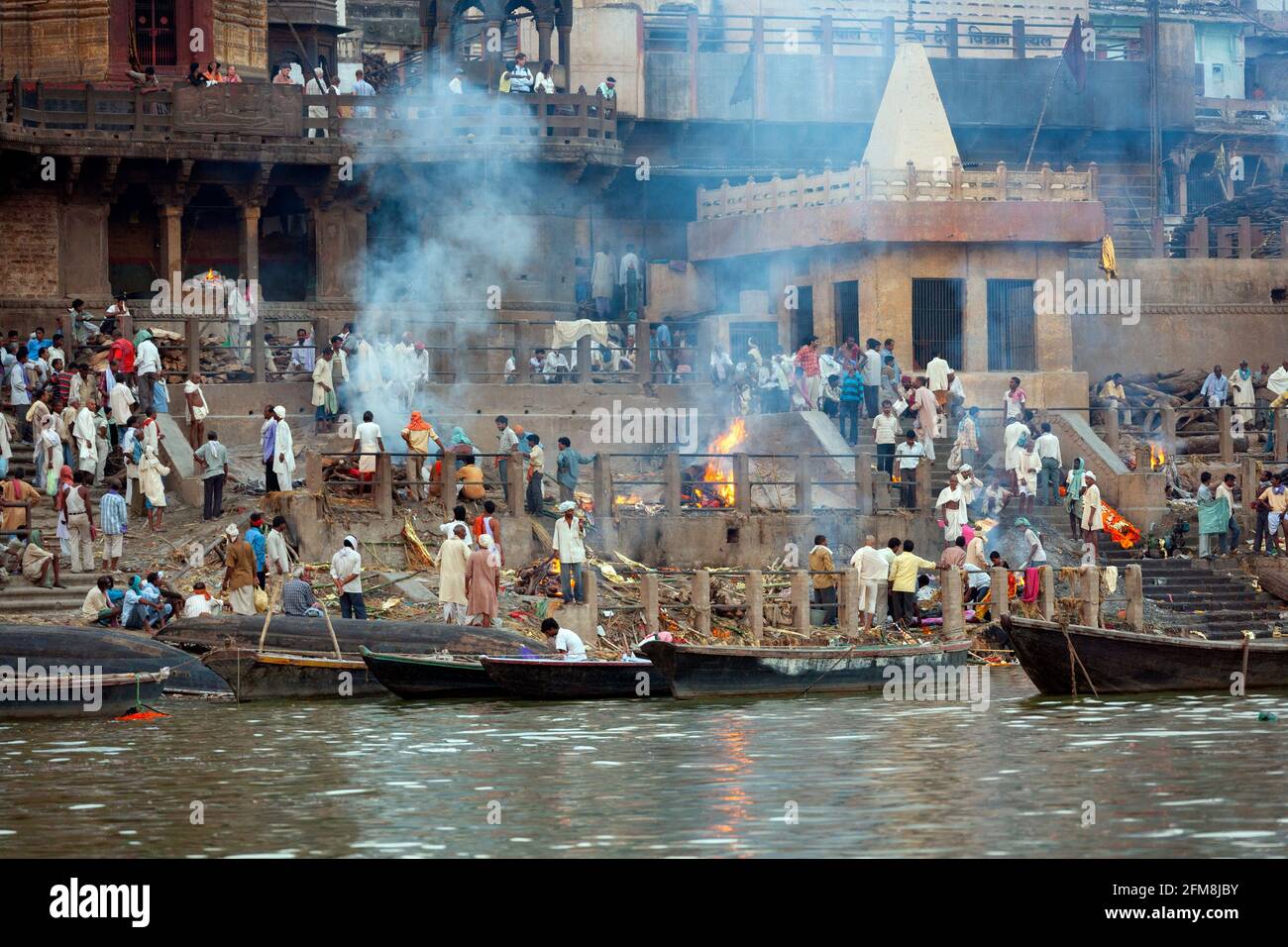 La cremazione indù Ghats sulle rive del fiume sacro Gange a Varanasi in India del nord. Foto Stock