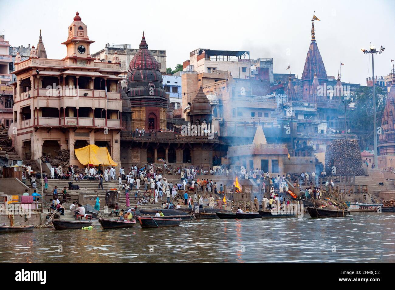 La cremazione indù Ghats sulle rive del fiume sacro Gange a Varanasi in India del nord. Foto Stock