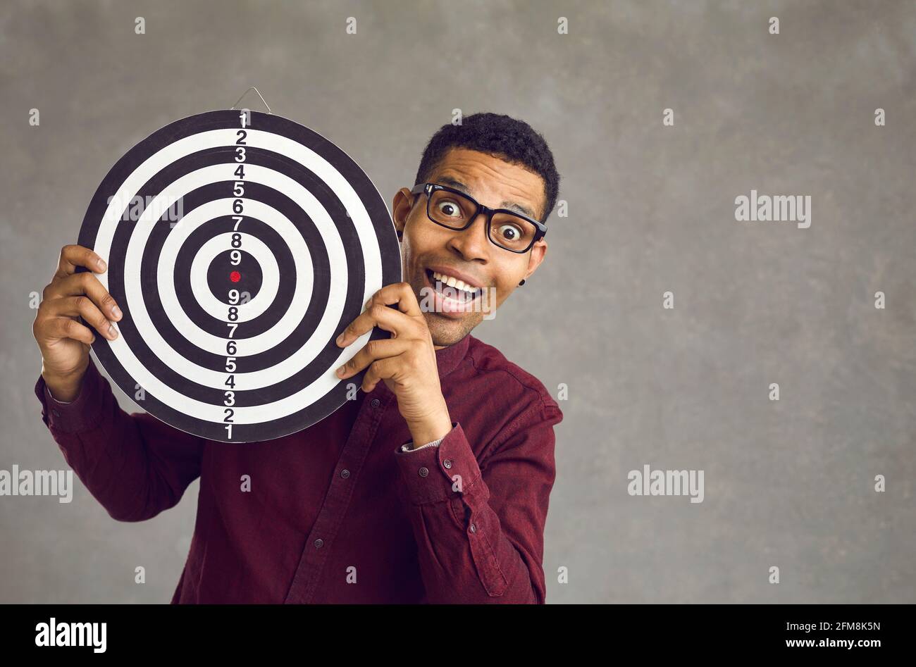 Felice uomo nero tenendo dartboard come concetto di pubblico di destinazione e l'obiettivo aziendale Foto Stock