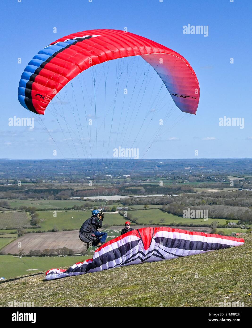 Brighton UK 7 maggio 2021 - UN parapendio deve prendere azione evasiva come si schianta quasi in un altro pilota come decollano da Devils Dyke appena a nord di Brighton sul South Downs in una bella giornata di sole . Alcuni dei parapendio speravano di arrivare fino a Margate in Kent come hanno fatto il massimo delle condizioni di volo perfette: Credit Simon Dack / Alamy Live News Foto Stock