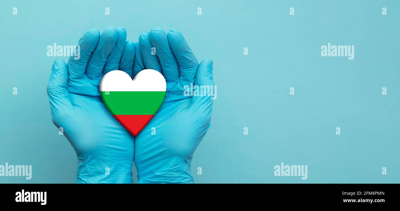 I medici indossano le mani dei guanti chirurgici che tengono il cuore della bandiera della Bulgaria Foto Stock