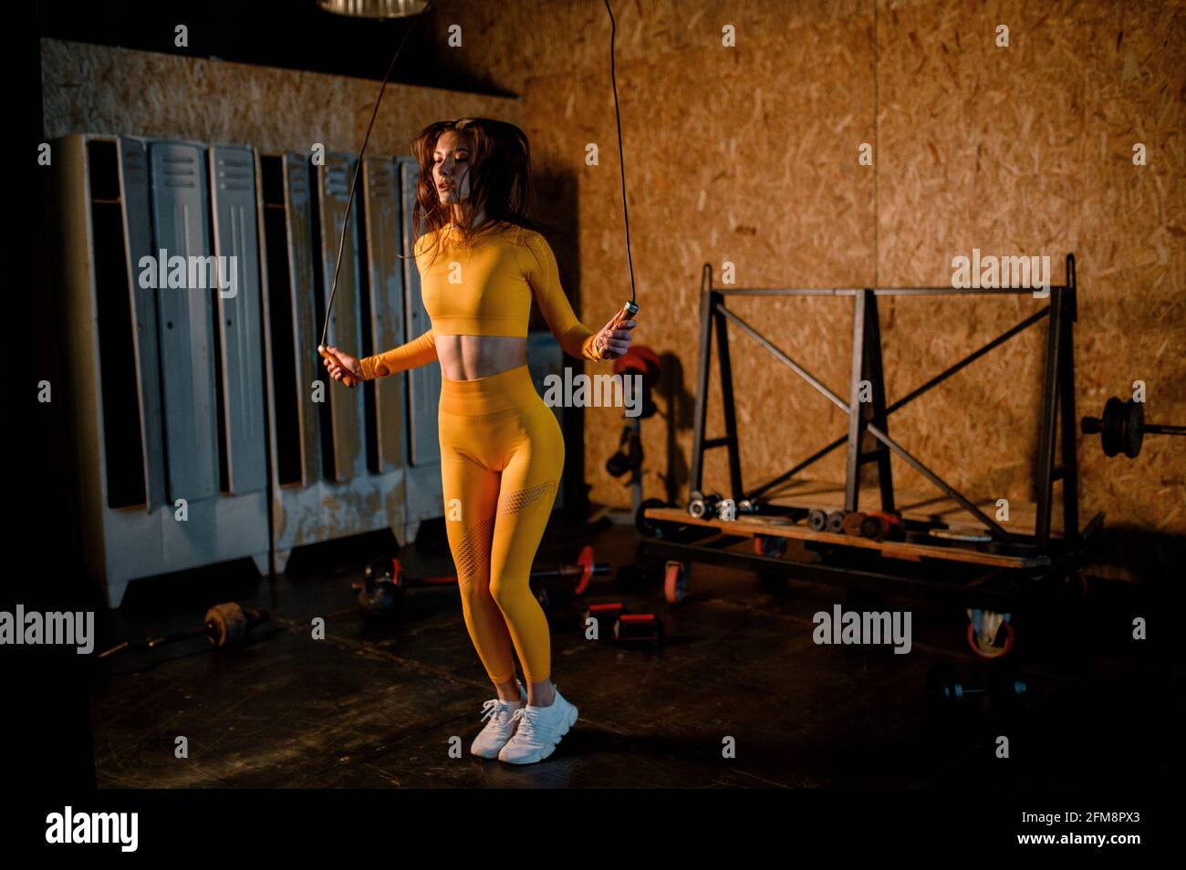 una ragazza sportiva salta su una corda in una palestra moderna. foto in movimento Foto Stock