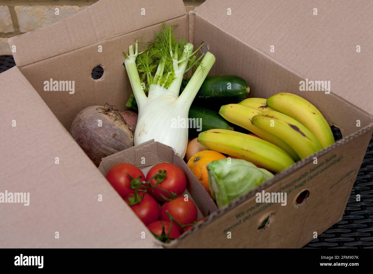 All'interno della scatola: Una consegna di verdura biologica contenente frutta e verdura confezionata in una scatola restituibile/riutilizzabile di Abel e Cole. Senza plastica. Foto Stock