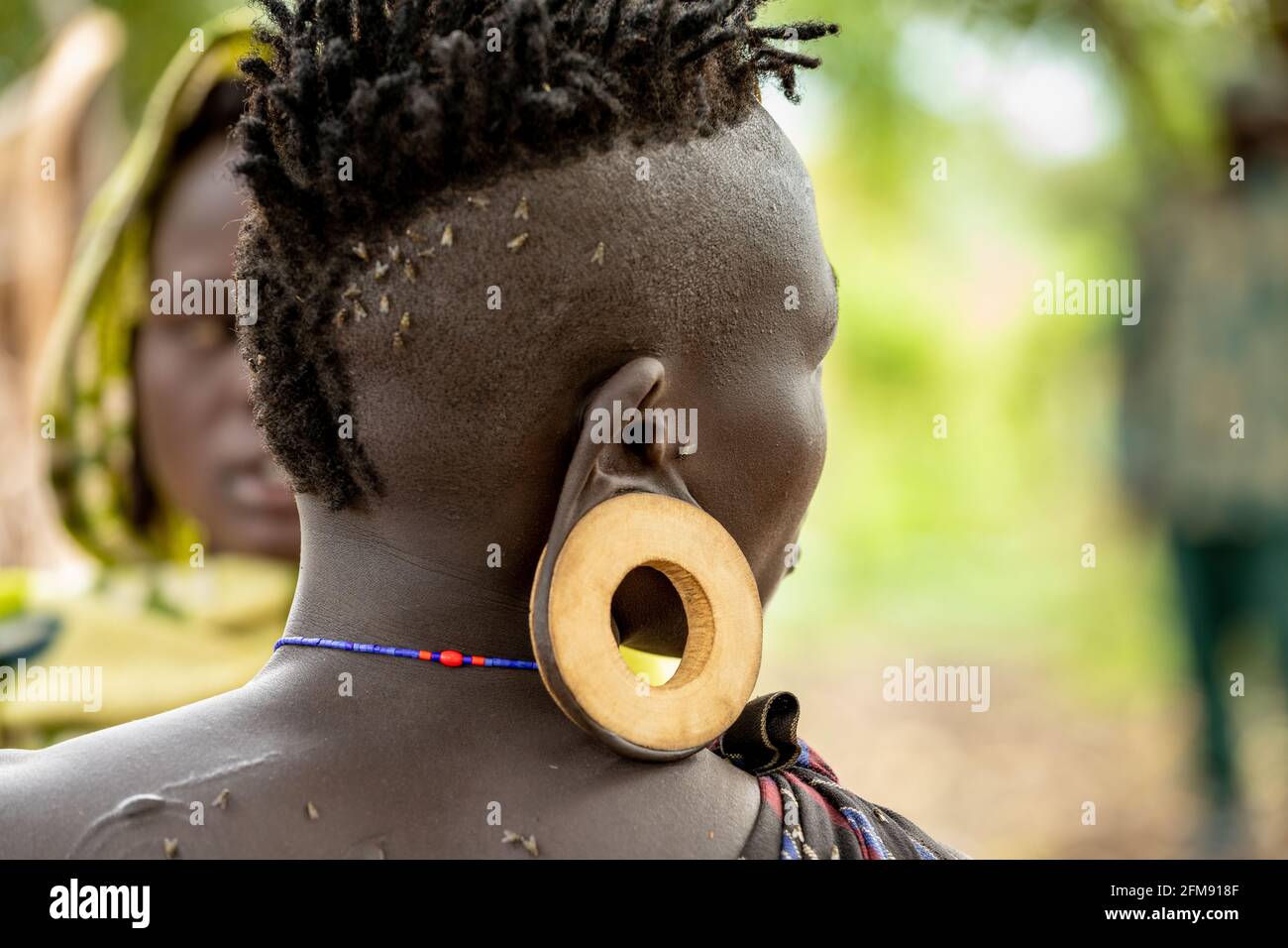 Alcuni dei membri maschi della tribù indossano i piatti nelle loro orecchie. DEBUB OMO ZONE, ETIOPIA: INCONTRA LA tribù dove le donne iniziano a stendere le labbra Foto Stock