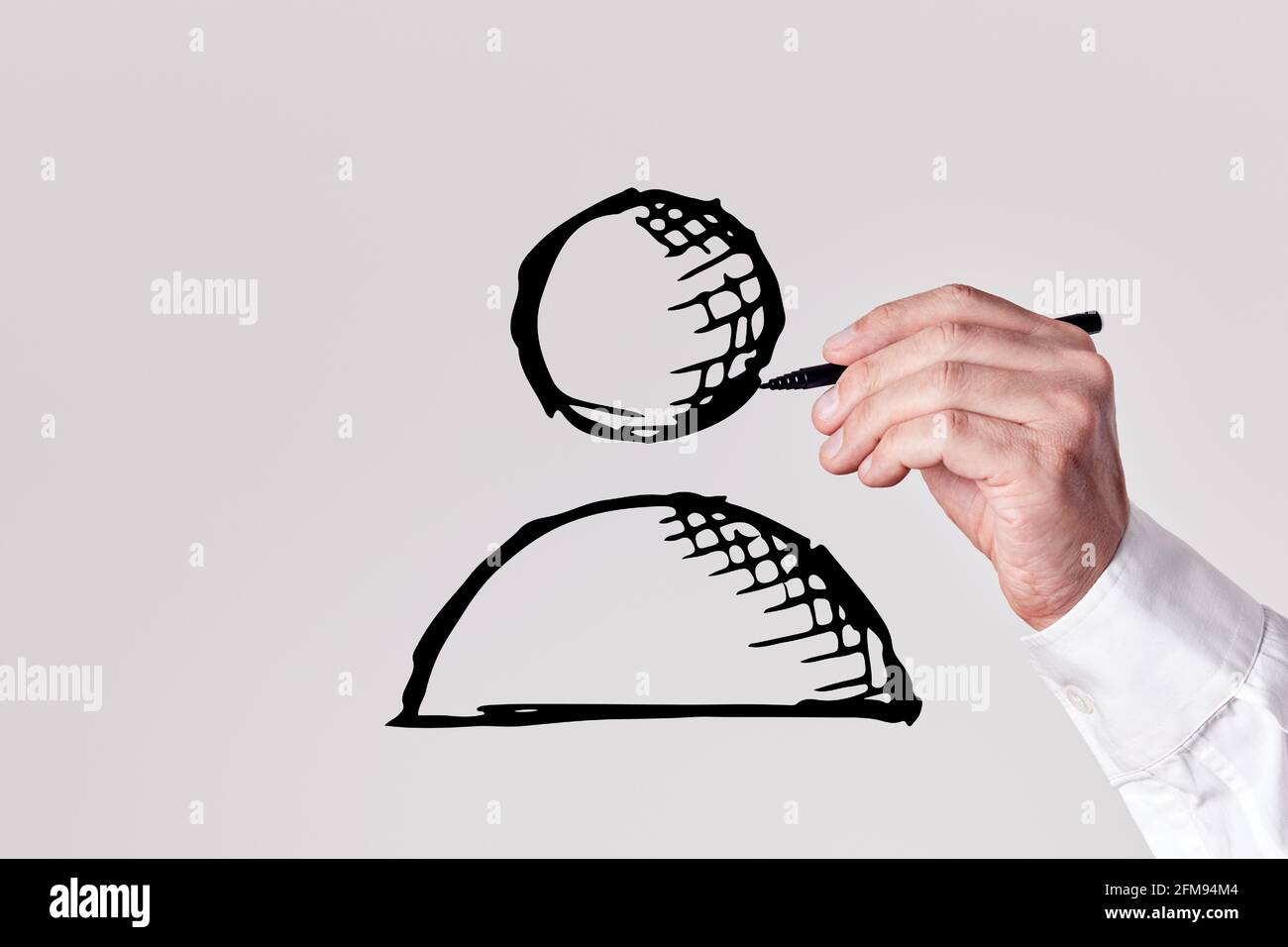 Un uomo d'affari con una penna disegna un'icona di un dipendente su sfondo grigio. Risorse umane o concetto di occupazione per il reclutamento di posti di lavoro. Foto Stock
