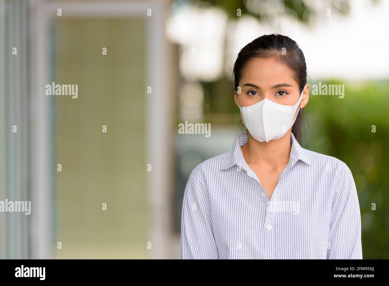 Donna asiatica che indossa maschera viso per proteggere dal coronavirus Covid-19 shot orizzontale Foto Stock
