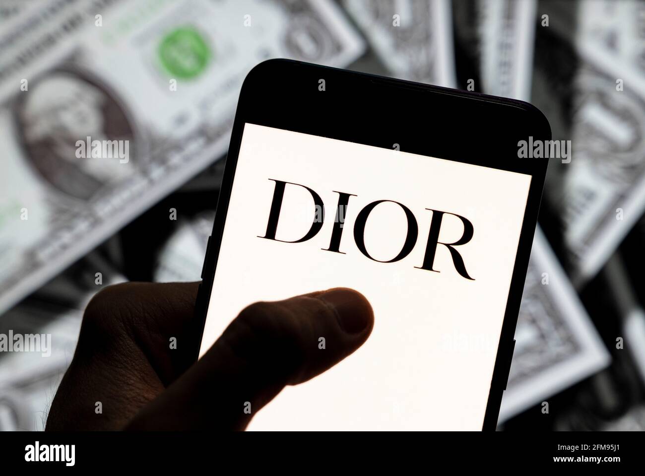 Cina. 21 Apr 2021. In questa illustrazione della foto i beni di lusso francesi, tali abbigliamento e prodotti di bellezza marchio Christian Dior logo visto su uno smartphone con USD (dollaro degli Stati Uniti) valuta in background. Credit: Budrul Chukrut/SOPA Images/ZUMA Wire/Alamy Live News Foto Stock