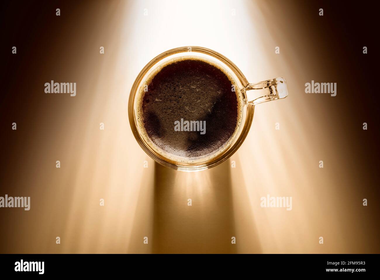 tazza da caffè con caffè nero, vista dall'alto sullo sfondo con luce solare. Foto Stock