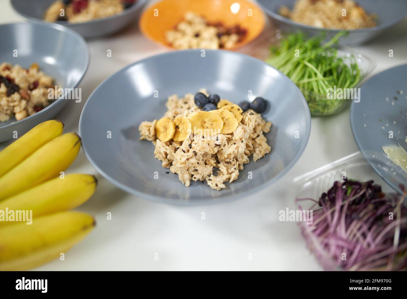 Primo piano di porridge gustoso e sano con frutta fresca in bella piastra blu. Concetto di cottura a processo delizioso piatto a casa con ingredienti gustosi, verdure fresche e frutta. Foto Stock