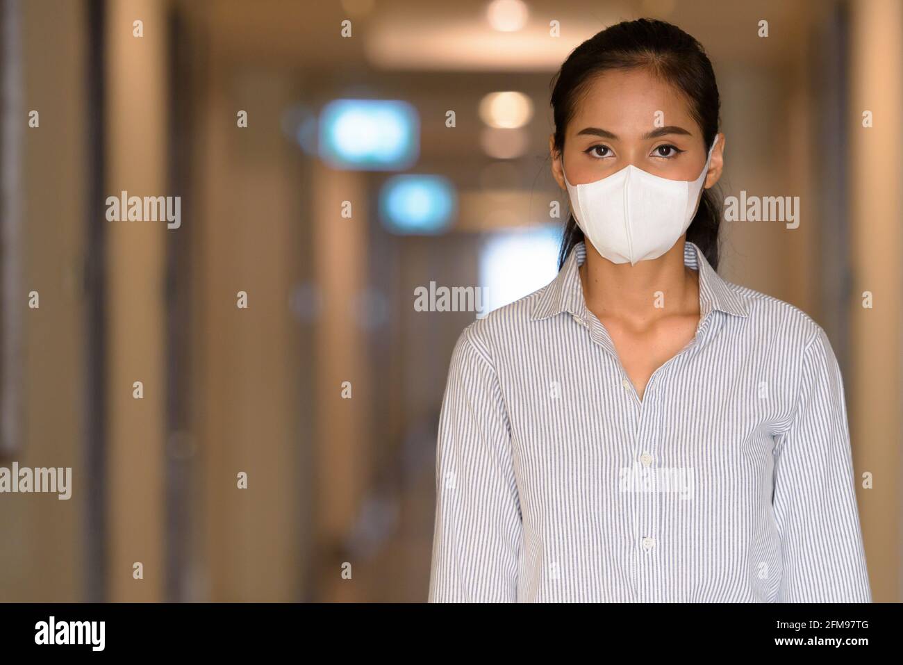 Donna asiatica che indossa maschera viso per proteggere dal coronavirus Covid-19 shot orizzontale Foto Stock