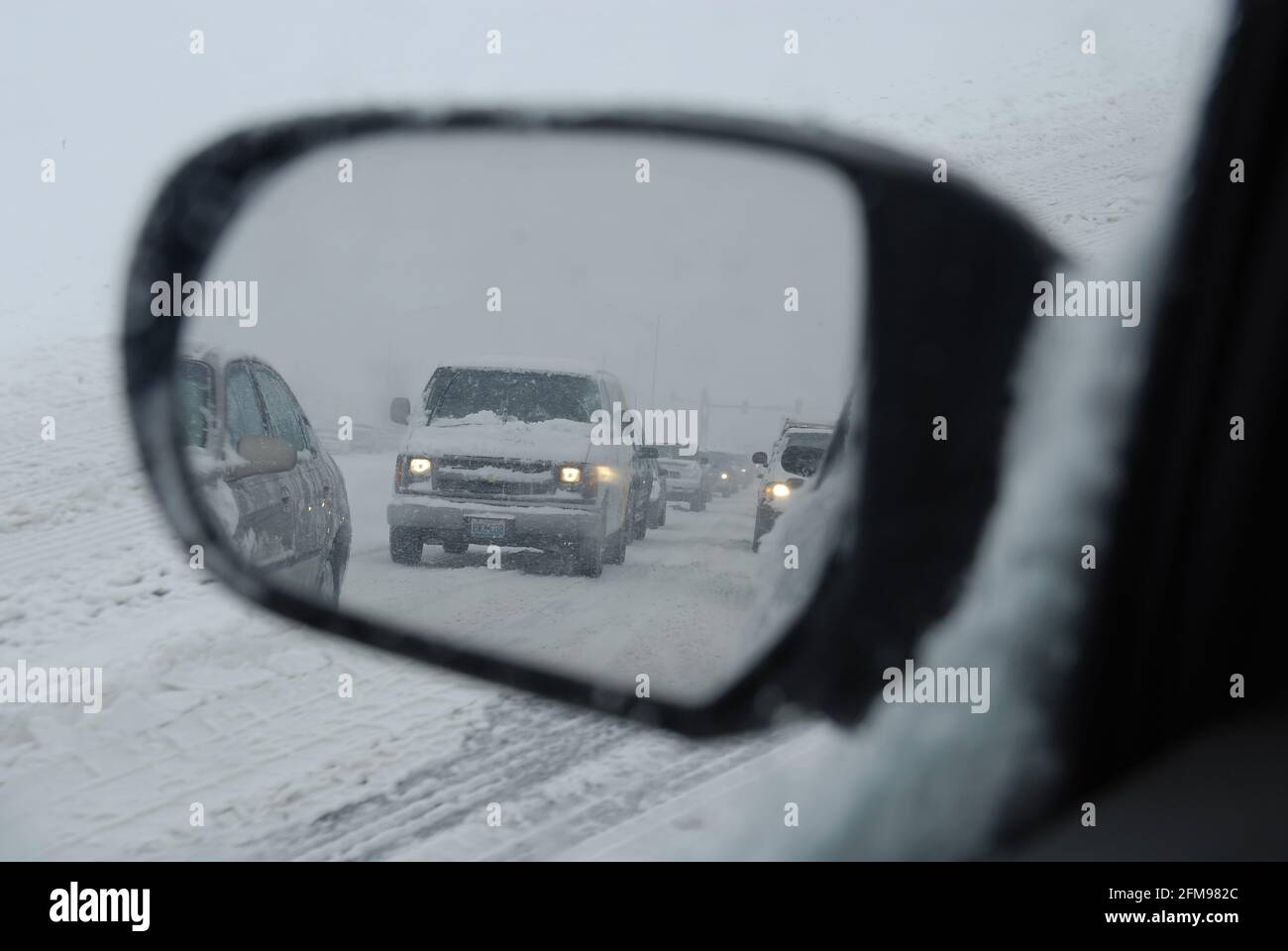 ST. LOUIS, STATI UNITI - Mar 05, 2008: Vista nello specchio del conducente di grande backup del traffico su un'autostrada in Missouri durante una tempesta di neve pesante. Foto Stock