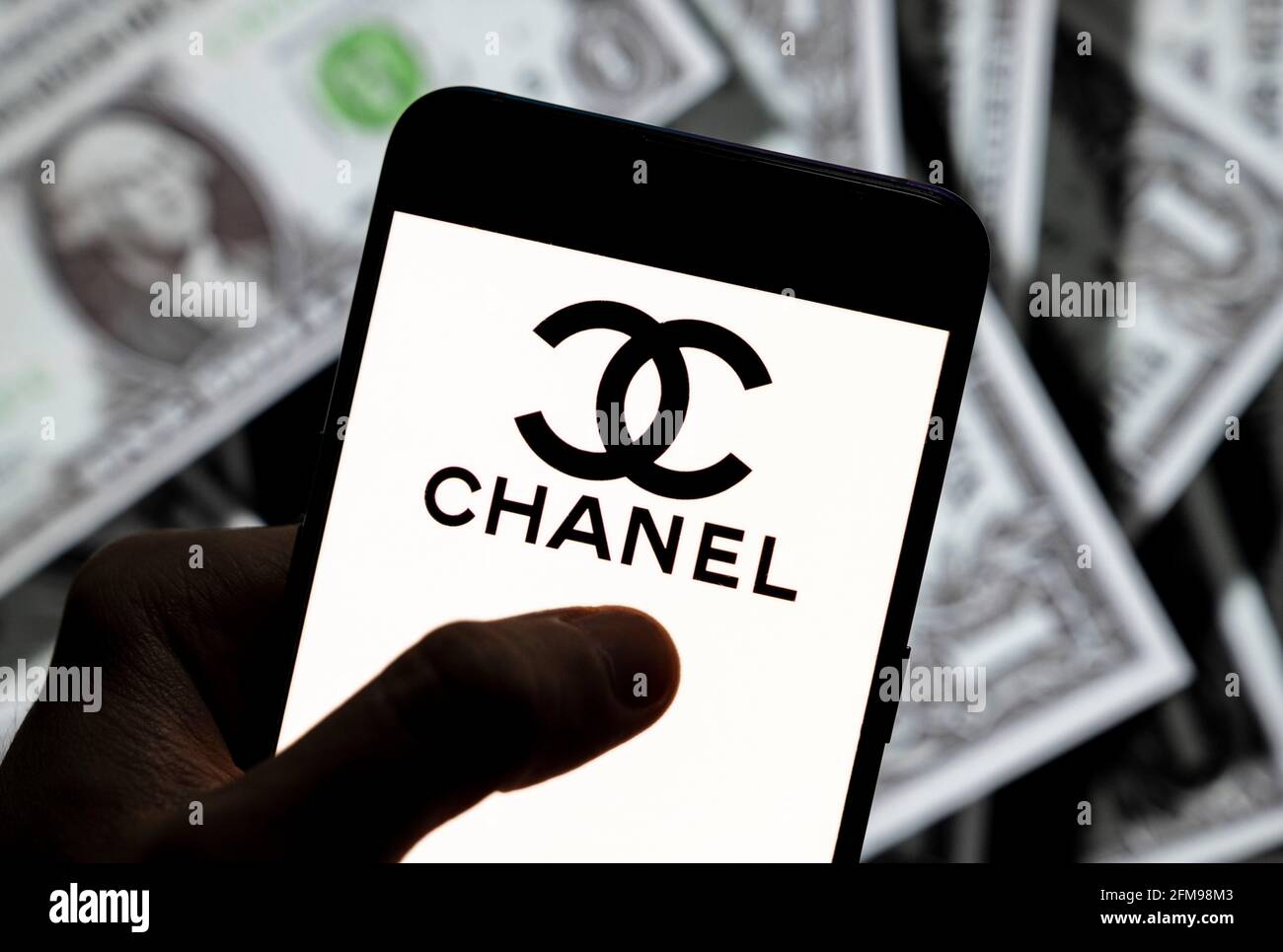 In questa illustrazione della foto il marchio francese di bellezza cosmetica multinazionale Chanel visto visualizzato su uno smartphone con la valuta USD (dollaro degli Stati Uniti) in background. Foto Stock