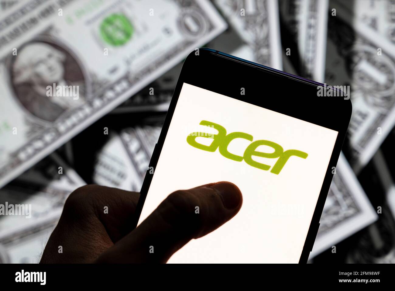 In questa illustrazione fotografica il logo Acer della multinazionale taiwanese dell'hardware e dell'elettronica è stato visualizzato su uno smartphone con la valuta USD (dollaro statunitense) sullo sfondo. Foto Stock