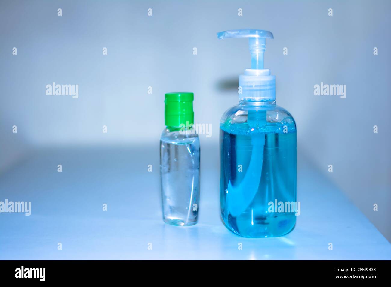 Bottiglie blu di disinfettante per le mani e gel antibatterico per le mani, lavaggio delle mani, igiene delle mani per la prevenzione dei virus Corona Foto Stock