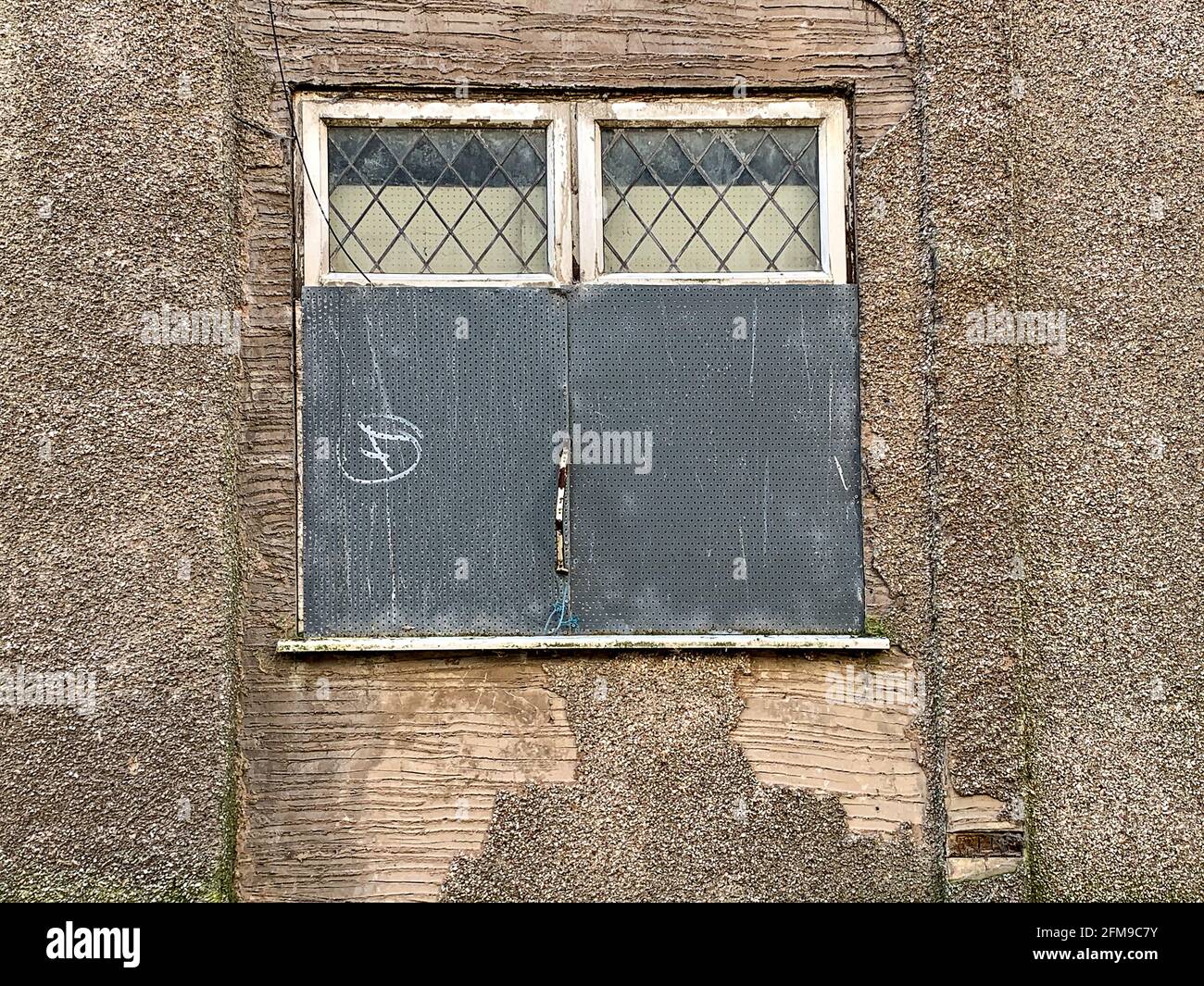 Finestra stradale protetta da griglia di sicurezza perforata in metallo Foto Stock