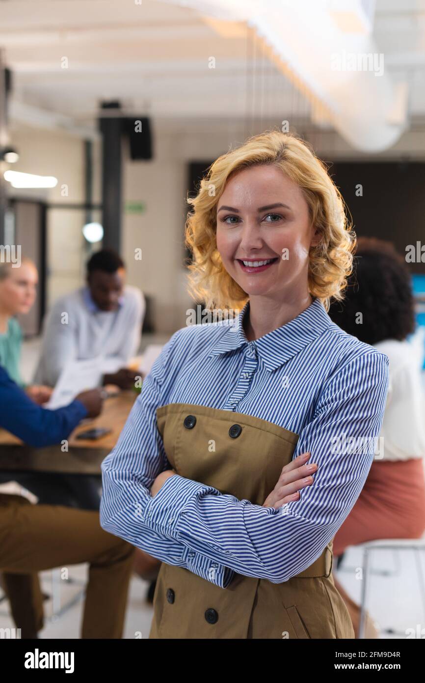 Ritratto di donna caucasica sorridente mentre si trova in un ufficio moderno Foto Stock