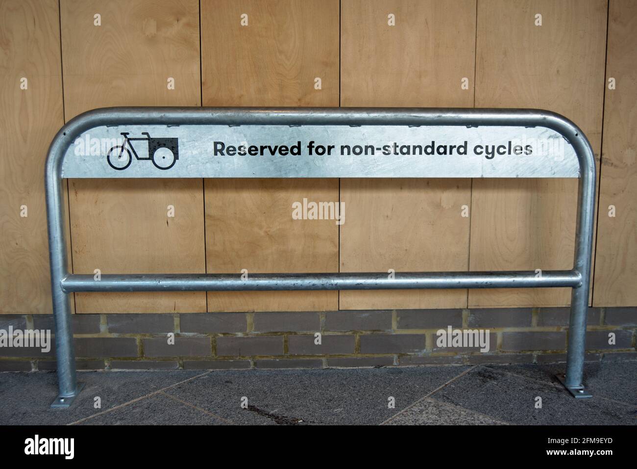 stand ciclabile presso la stazione ferroviaria di kingston, surrey, inghilterra, riservato ai cicli non standard e contrassegnato con testo e logo di una bicicletta da carico Foto Stock