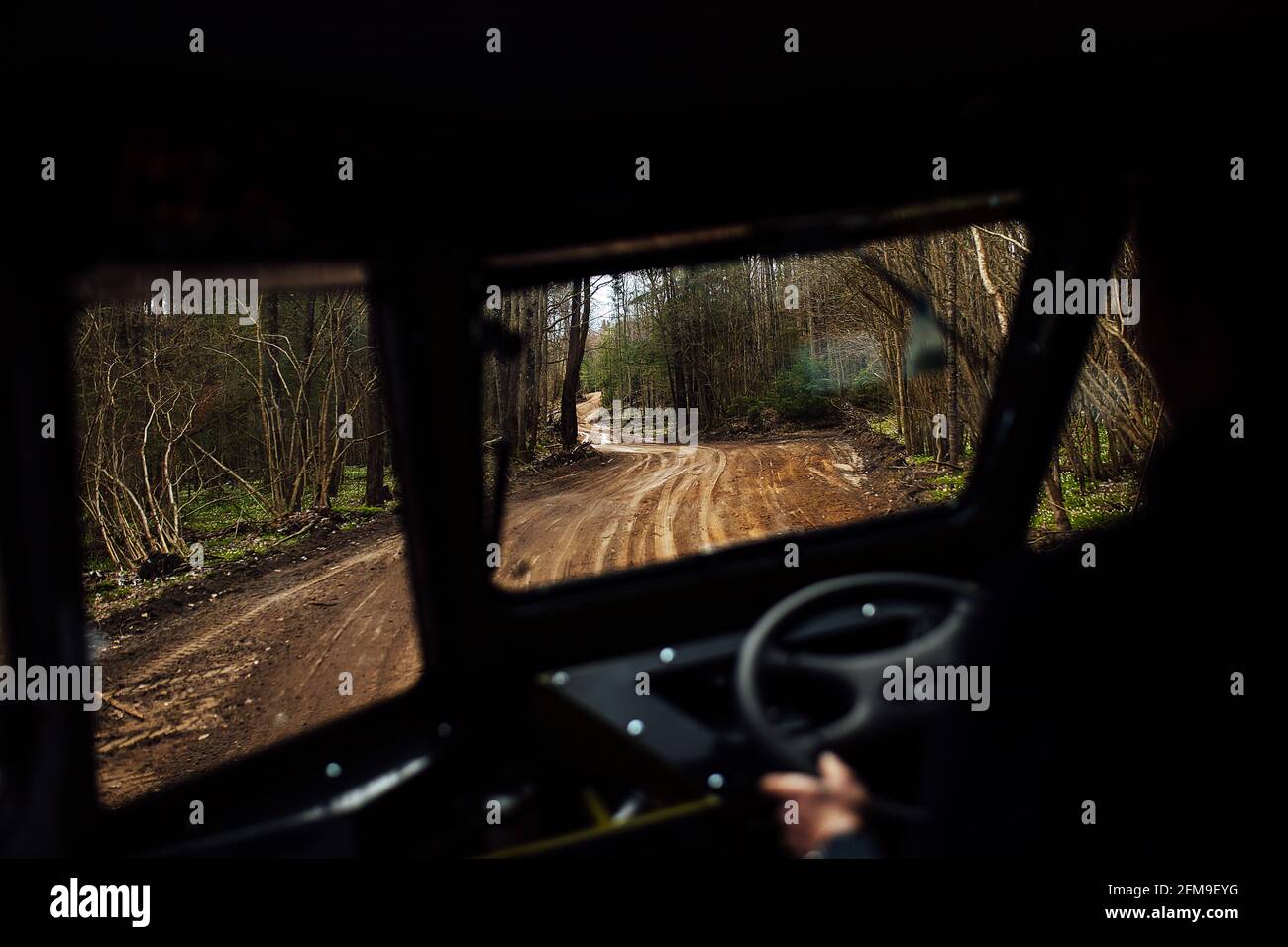 Vista dall'interno del SUV in fuoristrada. Viaggia attraverso i luoghi selvaggi in auto con traffico elevato. Vista dal sedile del passeggero al conducente Foto Stock