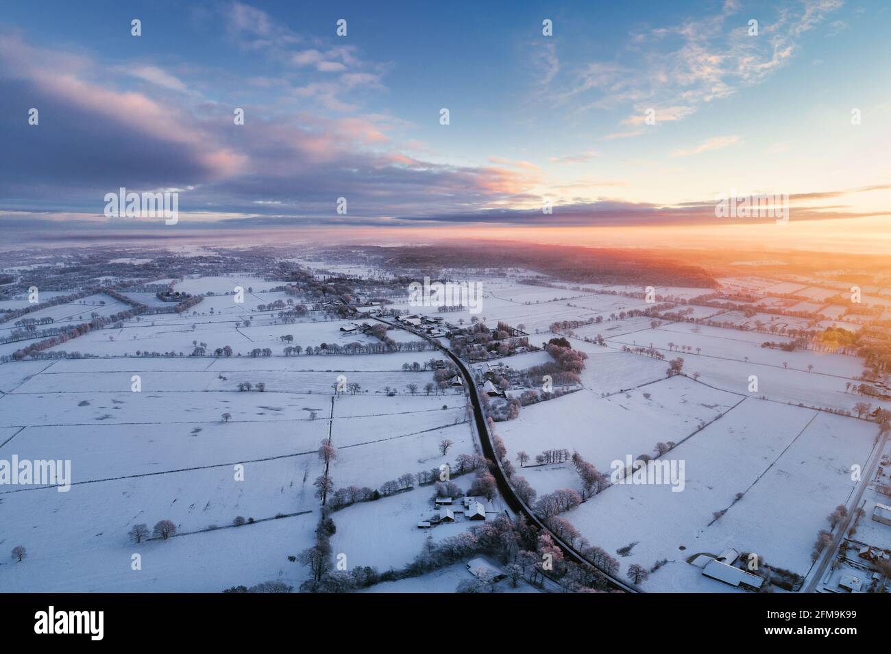 Alba a Wiesmoor, Eastfrisa in una fredda mattina d'inverno con neve e un'alba colorata. Foto Stock