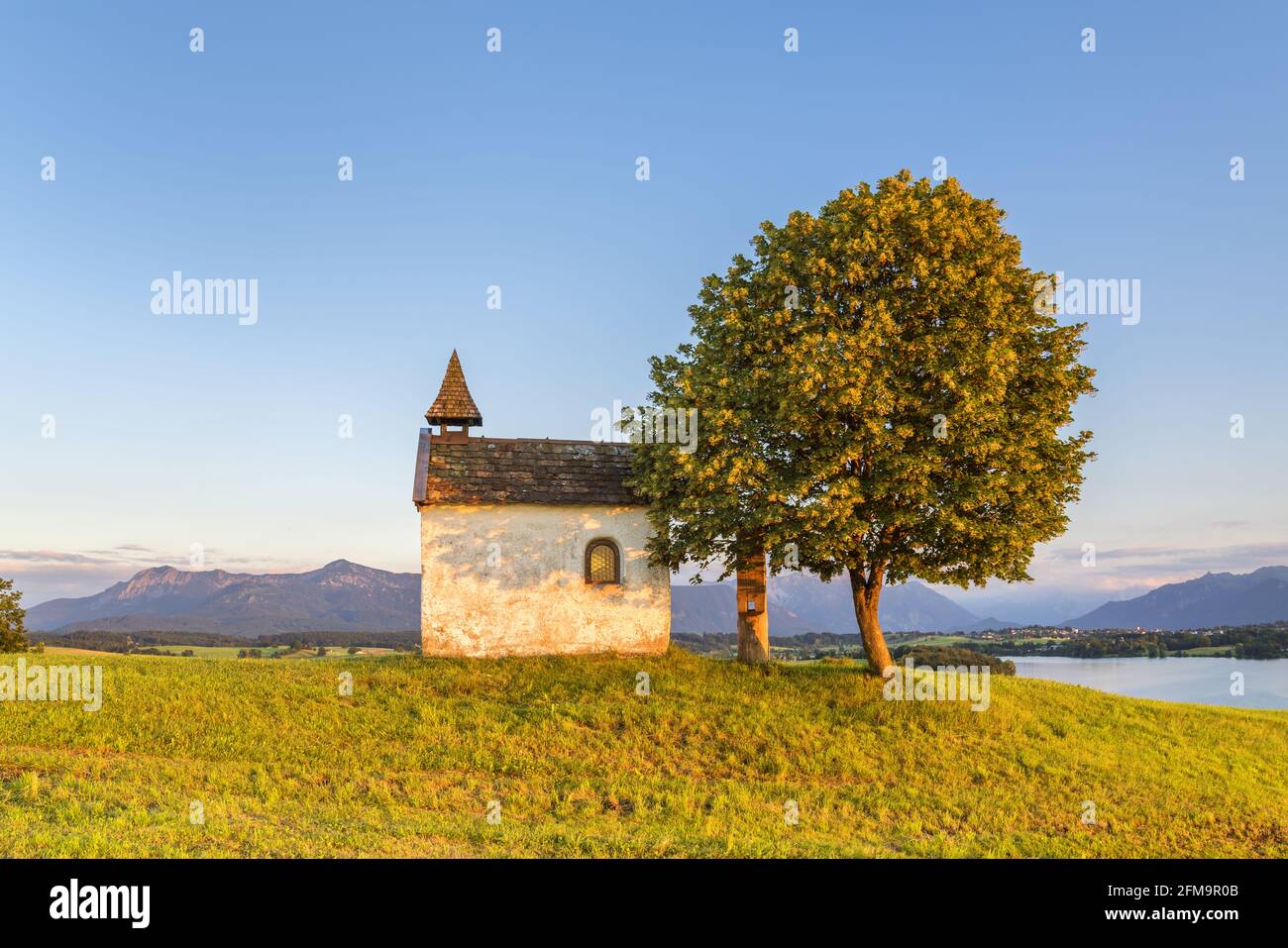 Mesnerhauskapelle su Aidlinger Höh con vista su Herzogstand e Heimgarten e sul Riegsee, Aidling, Riegsee am Riegsee, alta Baviera, Baviera, Germania Foto Stock