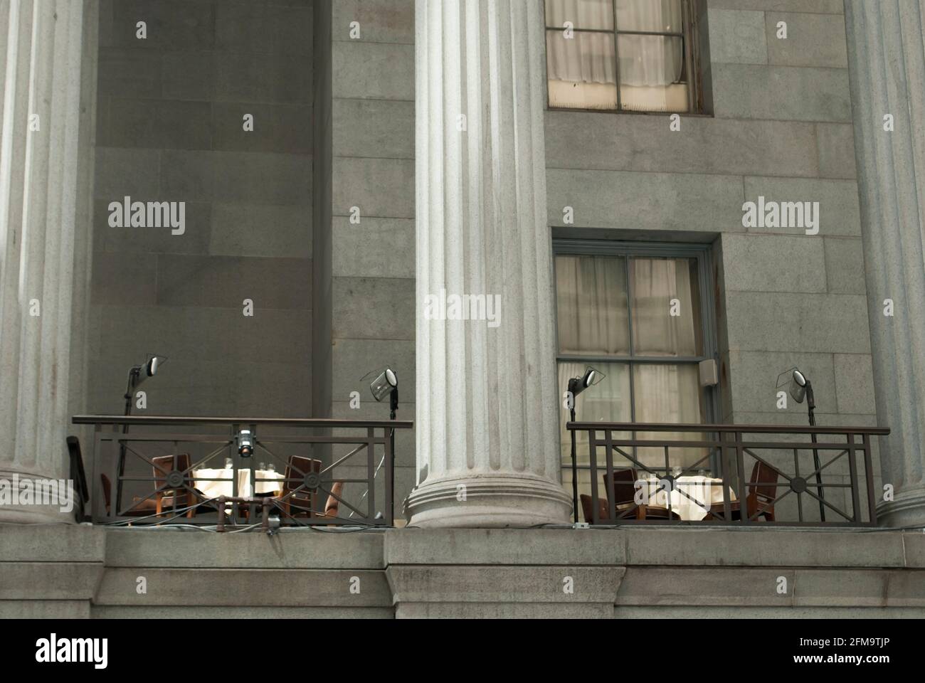 Wall Street, New York, Stati Uniti. Edificio del mercato azionario. Due tavoli da ristorante sul balcone. Concetto che cosa è sul tavolo. Foto Stock