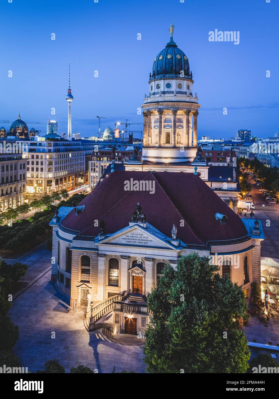 Tramonto sul Gendarmenmarkt di Berlino illuminato con la Cattedrale francese e la Cattedrale tedesca e la Torre della televisione di Berlino sullo sfondo. Foto Stock