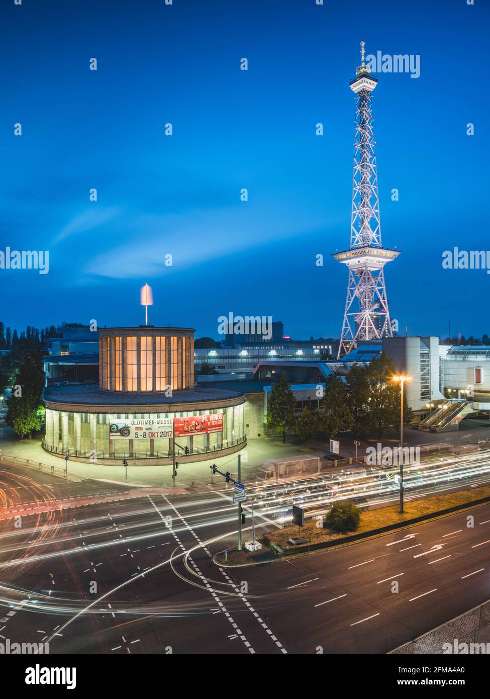 Traffico stradale di fronte alla torre radiofonica di Berlino illuminata sul terreno espositivo al crepuscolo. Foto Stock