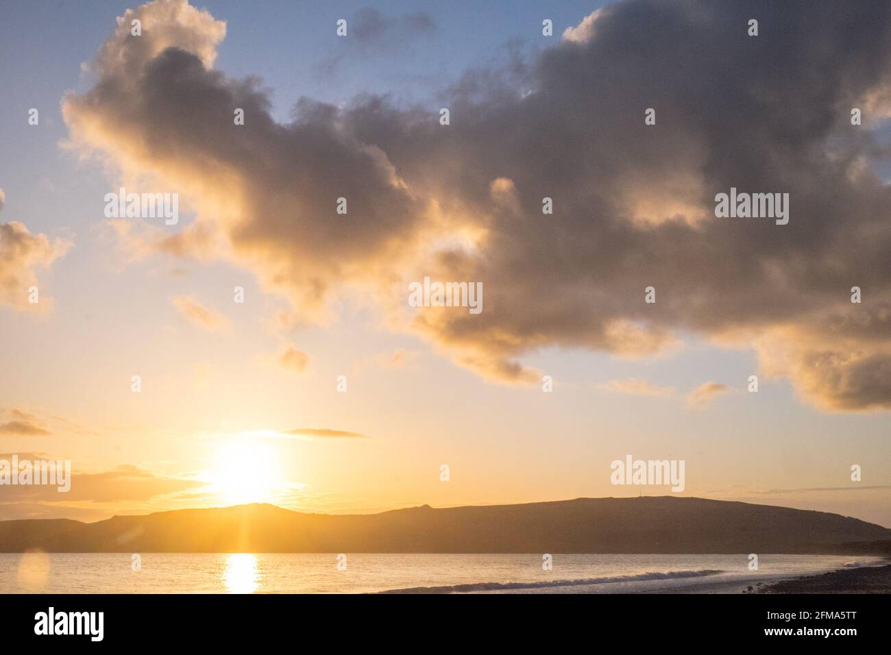 Tramonto,tramonto,tramonto,sole,a,Port Neigwl,Porth Neigwl Beach,noto anche come, aka, Hell's Mouth,drammatico,nuvole,su,popolare,surf,surf,spiaggia,mare,mare,mare,villaggio,ovest,Mid,Galles del Nord,,contea,vacanza estiva gallese,staycation,resort.Regno Unito,GB,Europa.Porth Neigwl, è conosciuta anche come 'a circa 3 miglia di una larga costa dell'Inferno, nella regione inglese, nella regione di Llŷn. La baia si affaccia a sud-ovest e si trova tra i promontori di Mynydd Rhiw a ovest e Mynydd Cilan a est Foto Stock