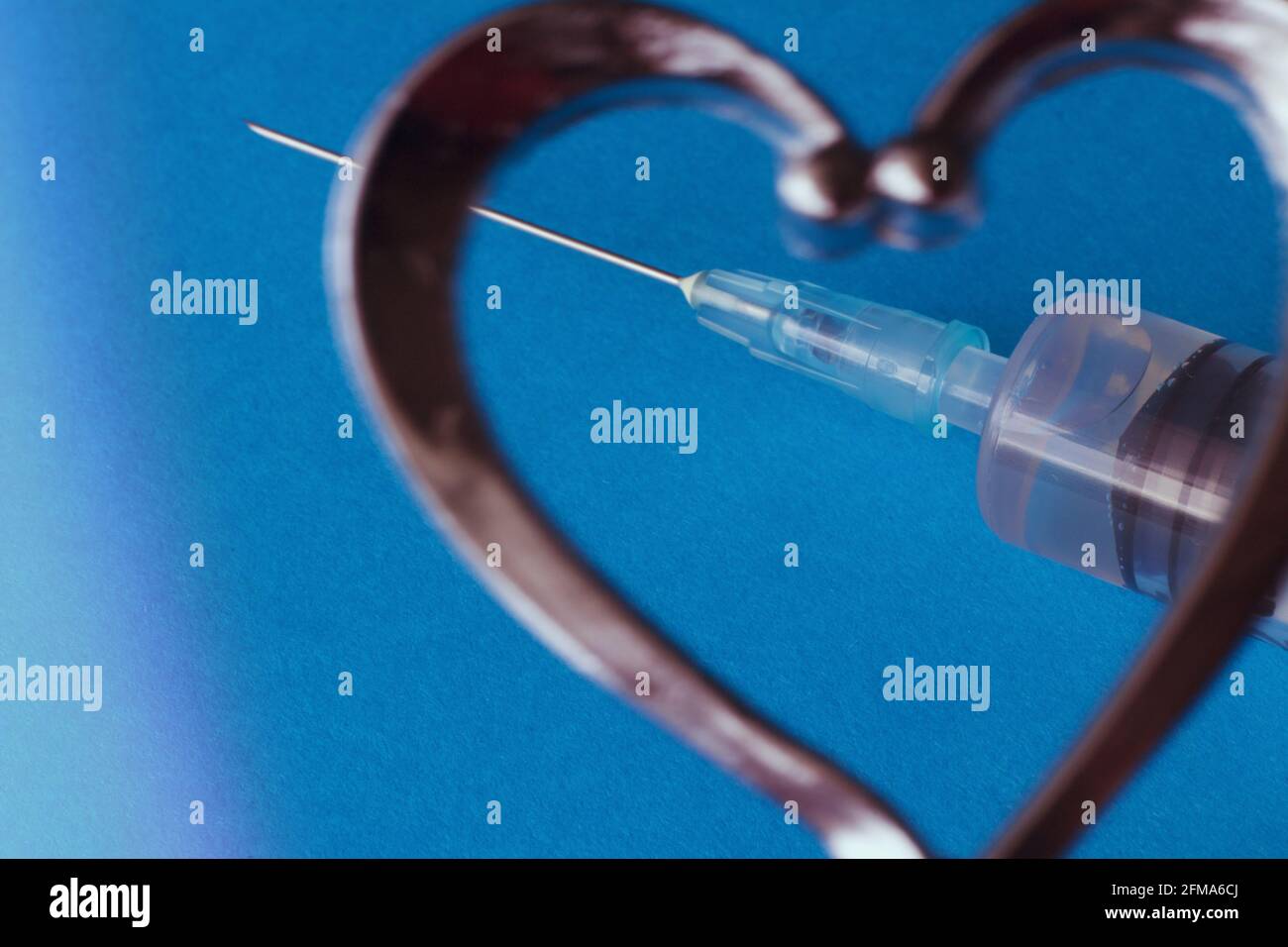 Primo piano di una siringa a forma di cuore . Foto Stock
