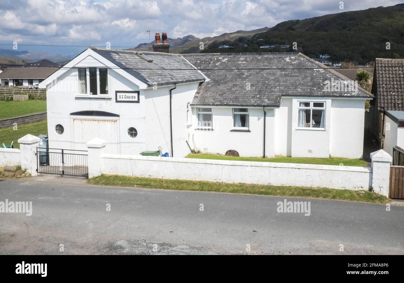 Fairbourne, Fairbourne è un villaggio sul mare gallese. Si trova sulla costa di Barmouth Bay nella comunità di Arthog, a sud dell'estuario del fiume Mawddach a Gwynedd, circondato dal Parco Nazionale di Snowdonia. Si trova in un'area elencata dal consiglio Gwynedd per il ritiro gestito a causa dei livelli del mare in aumento. Piani di abbandonare la difesa del mare maintenance.This villaggio potrebbe essere perso ai prezzi sea.breaching,breach,seawall,property,for,sale,Property hanno annuito dived. Caduto bruscamente Foto Stock