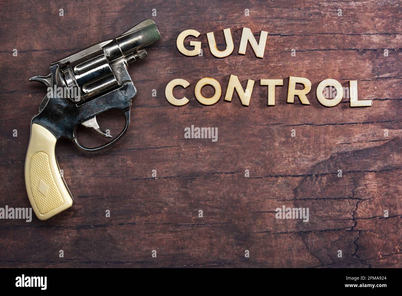 concetto di controllo della pistola con testo su sfondo di legno con pistola Foto Stock