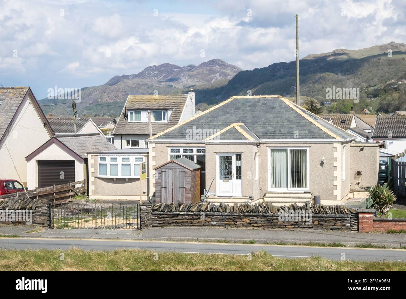Fairbourne, Fairbourne è un villaggio sul mare gallese. Si trova sulla costa di Barmouth Bay nella comunità di Arthog, a sud dell'estuario del fiume Mawddach a Gwynedd, circondato dal Parco Nazionale di Snowdonia. Si trova in un'area elencata dal consiglio Gwynedd per il ritiro gestito a causa dei livelli del mare in aumento. Piani di abbandonare la difesa del mare maintenance.This villaggio potrebbe essere perso ai prezzi sea.breaching,breach,seawall,property,for,sale,Property hanno annuito dived. Caduto bruscamente Foto Stock