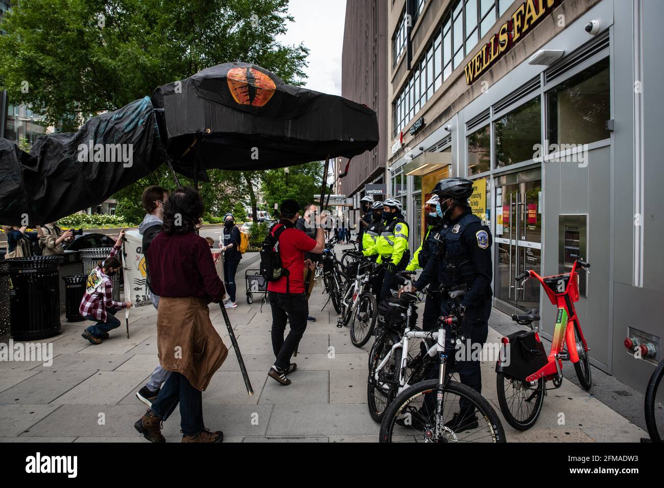 Washington DC, Stati Uniti. 07 maggio 2021. I manifestanti con un grande serpente di cartone si avvicinano a Wells Fargo a Washington, DC durante una marcia contro il sostegno della banca al gasdotto della linea 3 per le sabbie bituminose, il 7 maggio 2021. Gli attivisti ambientalisti con la Cut Down DC e la ribellione per l'estinzione hanno fatto pressione sulle principali banche affinché disinvestano i finanziamenti dal controverso gasdotto del Minnesota che chiamano una "bomba climatica a ticchettio" e si astengano da ulteriori investimenti nei combustibili fossili. Credit: Sipa USA/Alamy Live News Foto Stock