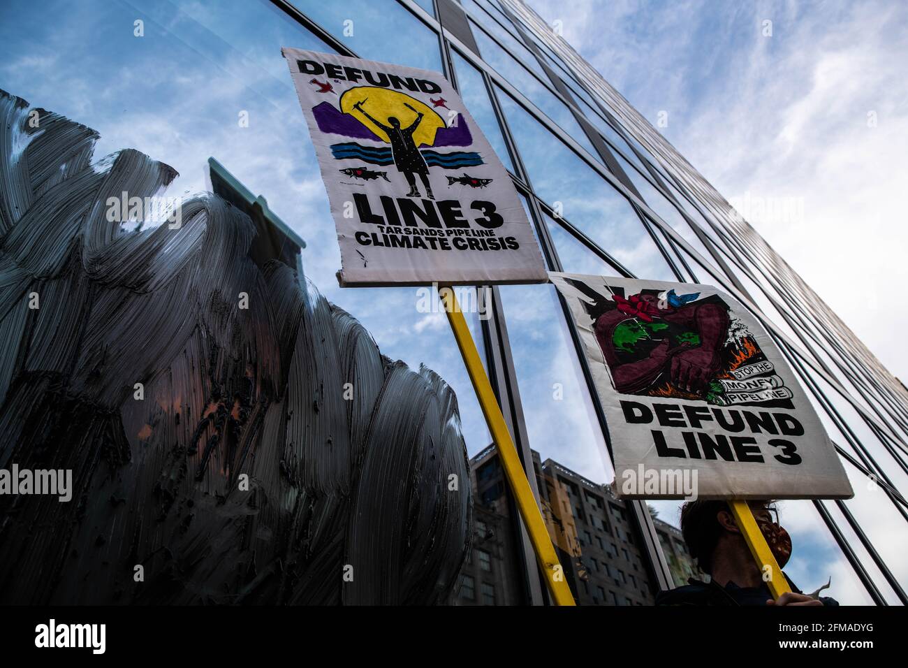 Washington DC, Stati Uniti. 07 maggio 2021. I segni sono visti contrapposti al gasdotto di sabbie bituminose della linea 3 dopo che i manifestanti hanno strisciato una sostanza simile al petrolio su una filiale della banca di Washington, DC il 7 maggio 2021. Gli attivisti ambientalisti con la Cut Down DC e la ribellione per l'estinzione hanno fatto pressione sulle principali banche affinché disinvestano i finanziamenti dal controverso gasdotto del Minnesota che chiamano una "bomba climatica a ticchettio" e si astengano da ulteriori investimenti nei combustibili fossili. Credit: Sipa USA/Alamy Live News Foto Stock