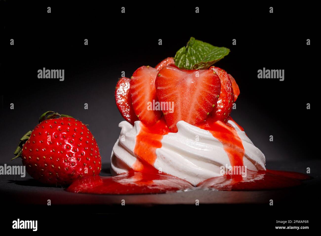 Mini Pavlova individuale di fragole con coulis di fragole Foto Stock
