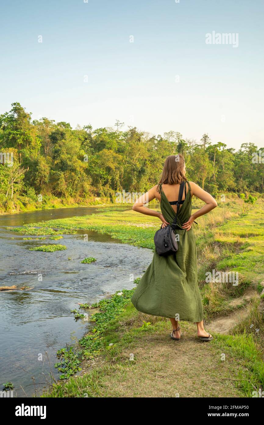 Giovane donna / turista vicino al fiume Rapti, Parco Nazionale di Chitwan, Distretto di Chitwan, Provincia di Bagmati, Nepal Foto Stock